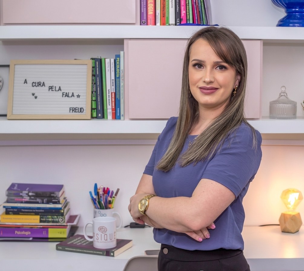 Amanda Brum em seu consultório, ao lado do letreiro A cura pela fala — Freud